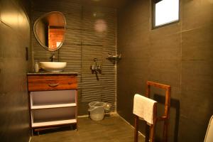 a bathroom with a sink and a mirror at Montane Chalet , Sethan in Manāli
