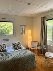 um quarto com uma cama, uma cadeira e uma janela em Ewa & Maude Hotel Aston Villa em Gotemburgo