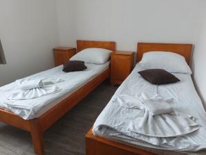two twin beds in a room withthritisthritislictslictslicts at Turistički centar Andrićgrad in Višegrad
