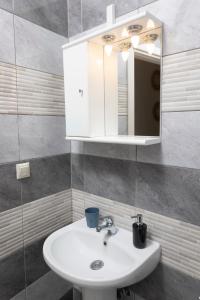 uma casa de banho com um lavatório branco e um espelho. em Anastasia Studios Hanioti em Hanioti