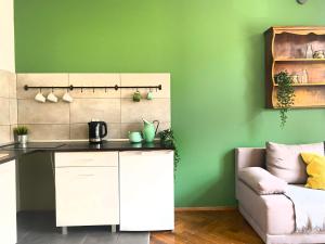 eine Küche mit grünen Wänden und einem Sofa in der Unterkunft Perfect place for couples, Piłsudskiego street - Old Town in Krakau