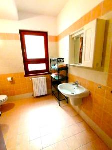 baño con lavabo y ventana en Casa Ghirlanda appartamenti, en Lazise