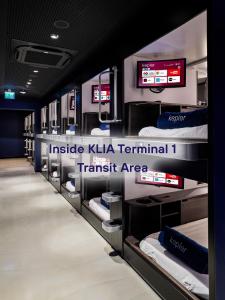 Kepler Club KLIA Terminal 1 - Airside Transit Hotel في سيبانغ: غرفة مع صف من الأسرّة بطابقين