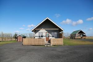 ein kleines Haus mit einem Zaun in einer Einfahrt in der Unterkunft Eldhraun Holiday Home in Kirkjubæjarklaustur
