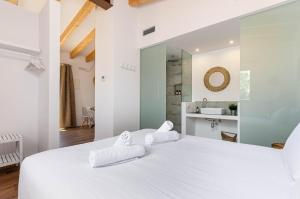 ein weißes Schlafzimmer mit einem großen weißen Bett und zwei Handtüchern in der Unterkunft Agroturismo Cal Tio 3 YourHouse in Costitx