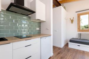 uma cozinha com armários brancos e azulejos verdes na parede em Agroturismo Cal Tio 3 YourHouse em Costitx