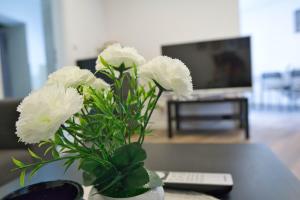 a vase with white flowers sitting on a table at Heide Ferienwohnung Nord Nr-1 in Schneverdingen