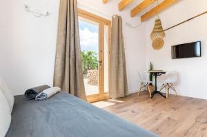 a bedroom with a bed and a window and a table at Agroturismo Cal Tio 3 YourHouse in Costitx