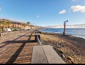 a wooden boardwalk on a beach with the ocean at Apartamento Eli Beach Tenerife in Candelaria