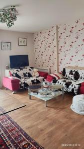 Sala de estar con 2 sofás y mesa en Chambre Rafaël chez particulier, en Cherbourg-en-Cotentin
