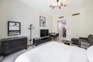a bedroom with a bed and a living room at Studio Huge Balcony Loreto 1 Damac Hills in Dubai Marina