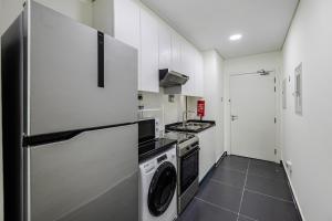 a kitchen with a refrigerator and a washer and dryer at Studio Huge Balcony Loreto 1 Damac Hills in Dubai Marina