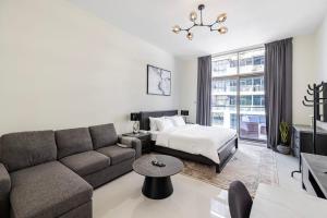 a living room with a couch and a bed at Studio Huge Balcony Loreto 1 Damac Hills in Dubai Marina