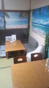 um quarto com um sofá, uma mesa e cadeiras em Nedokoro Minamihama Kujukuri - Vacation STAY 98351v em Kujukuri