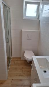un bagno con un water, un lavandino e una finestra di Apartments Anna a Zara (Zadar)