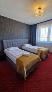 Pod Lipami في بيسترا: سريرين في غرفة نوم مع ثريا