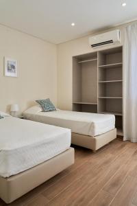 1 Schlafzimmer mit 2 Betten und einem Schrank in der Unterkunft LEGACY SUITES & APARTMENTS ALBUFEIRA AL in Albufeira