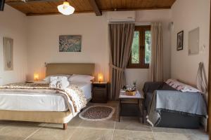 a bedroom with two beds and a couch at Fikardou Chalets in Phikardhou
