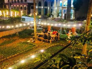 a group of people sitting in a courtyard at night at BB Hotel&Resort in Phú Quốc +79 photos
