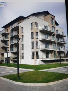 a large apartment building in front of a street at Mega Lux Apartament z Basenem & Spa z Parkingiem in Sianozety