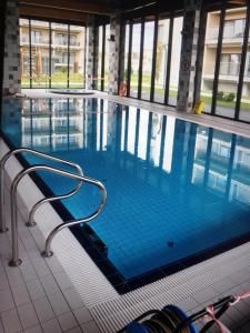 a swimming pool with a chair in a building at Mega Lux Apartament z Basenem & Spa z Parkingiem in Sianozety