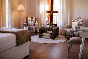 um quarto com 2 cadeiras, uma cama e uma mesa em La Farm Baleares em Santa Maria del Camí