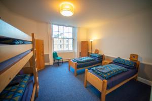 Glasgow Youth Hostel في غلاسكو: غرفة بسريرين بطابقين وأريكة