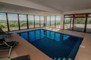 a large swimming pool in a house with windows at Dom z bali - Serafinówka in Tęgoborze