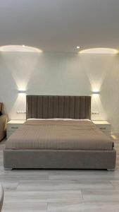 a large bed in a bedroom with two lights at Samarkand Central Apartments in Samarkand