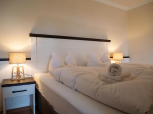 a bedroom with a white bed with two lamps at App Scharbeutzchen in Scharbeutz