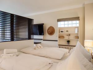 two beds in a white room with a window at App Scharbeutzchen in Scharbeutz
