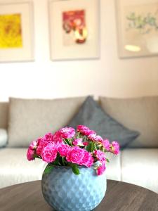 a blue vase with pink flowers on a table at Appartement Backbord in Morsum