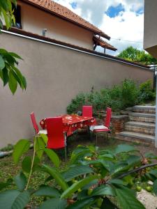 班基雅的住宿－Стаи за гости - Цветето на Ангела，院子里的红色桌子和椅子