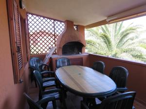 tavolo e sedie in una stanza con forno per pizza di Villetta Sunrise 6A a Costa Rei
