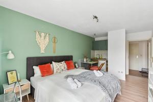 Schlafzimmer mit einem Bett mit orangefarbenen und grünen Wänden in der Unterkunft Salí Homes LM1 Studio mit guter Anbindung an die A9 in Bayreuth
