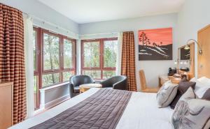 a bedroom with a large bed and windows at High Range Lodge Hotel in Aviemore