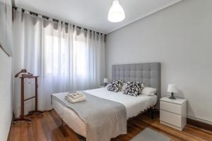 een slaapkamer met een groot bed en een groot raam bij Etxebarria apartment by People Rentals in Bilbao