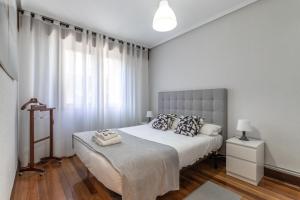 sypialnia z dużym łóżkiem i dużym oknem w obiekcie Etxebarria apartment by People Rentals w mieście Bilbao