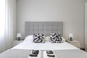 sypialnia z dużym białym łóżkiem z dwiema poduszkami w obiekcie Etxebarria apartment by People Rentals w mieście Bilbao