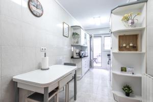 kuchnia ze stołem i zegarem na ścianie w obiekcie Etxebarria apartment by People Rentals w mieście Bilbao +24 zdjęcia