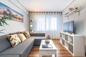 een woonkamer met een bank en een tv bij Etxebarria apartment by People Rentals in Bilbao