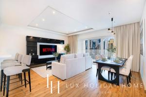 un salon avec un canapé et une table dans l'établissement LUX The Bonnington JLT Suite, à Dubaï