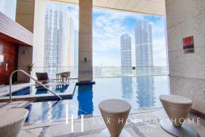une piscine dans un immeuble avec vue sur les gratte-ciel dans l'établissement LUX The Bonnington JLT Suite, à Dubaï