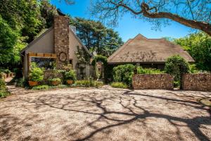 a house with a stone driveway in front at Festina Lente Guesthouse in Johannesburg