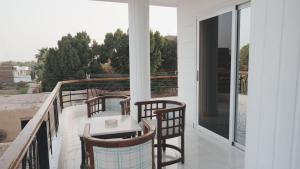 a balcony with three chairs and a table on it at Nile Ruby Luxor in Luxor