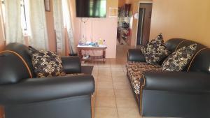 sala de estar con 2 sillas y sofá en Angie's Cove, modern get-away overlooking Castries en Castries