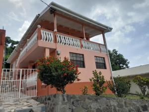 a pink house with a balcony and flowers at Angie's Cove, modern get-away overlooking Castries in Castries