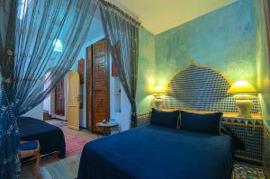 Un pat sau paturi într-o cameră la Dar El Mouhit