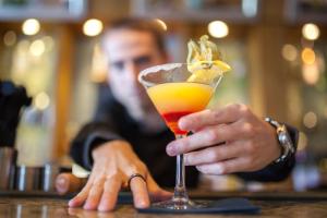 a man sitting at a bar holding a drink at The White Lion Hotel in Aldeburgh