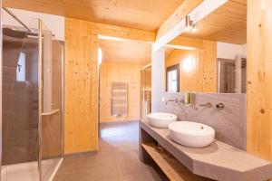 ein Bad mit 2 Waschbecken und einer Dusche in der Unterkunft Alpenchalets Reiteralm by ALPS RESORTS in Schladming